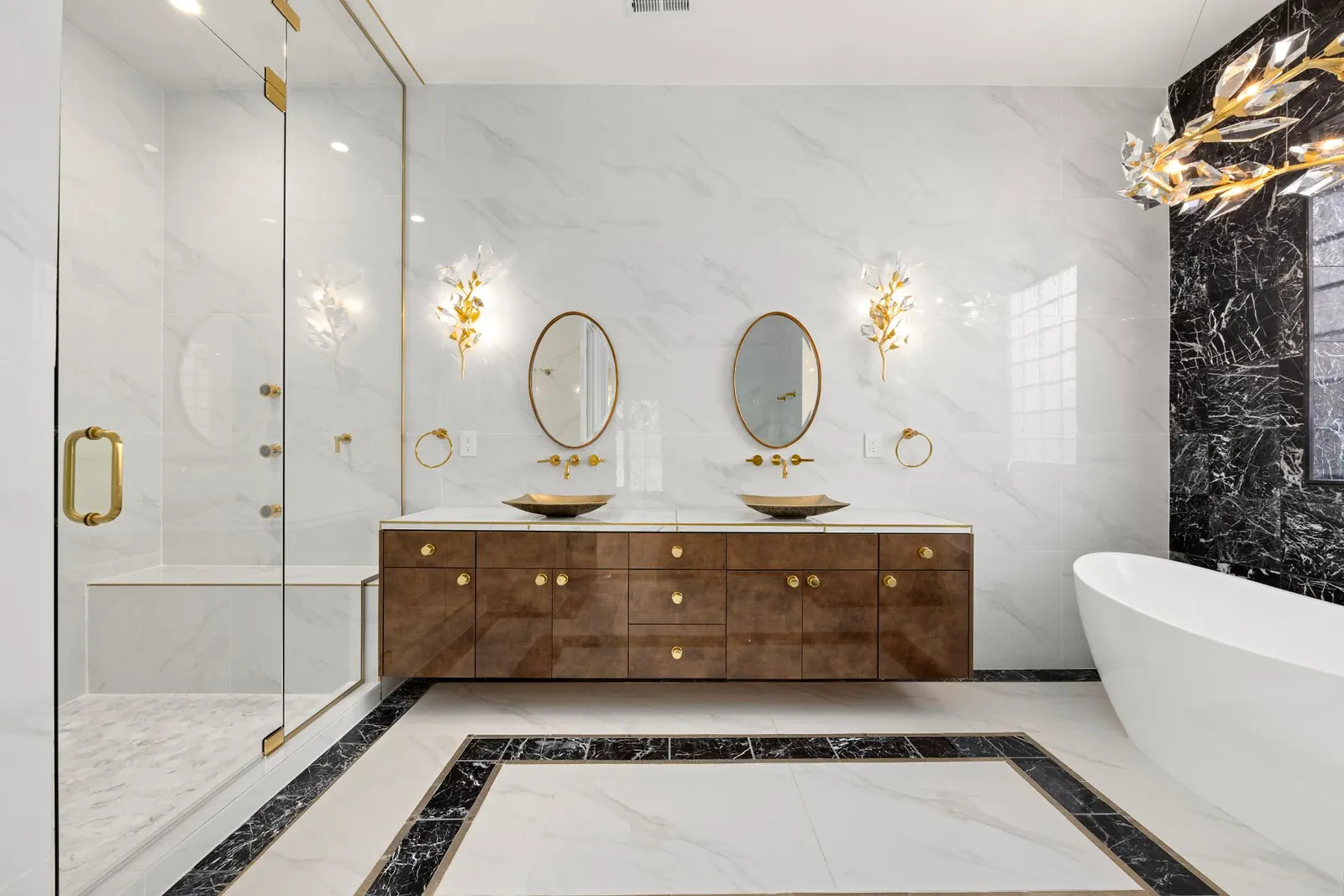 Baño de lujo en mármol blanco con detalles dorados, tina exenta y mueble de madera